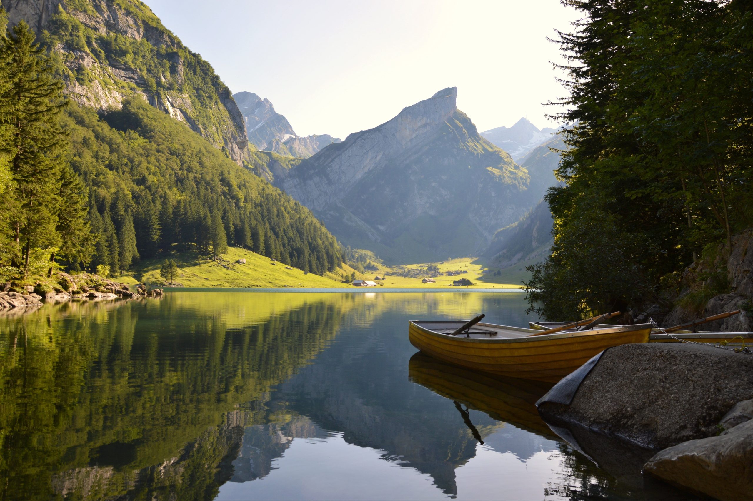 Schweizer See mit Boot und im Hintergrund steht ein grosser Berg. 